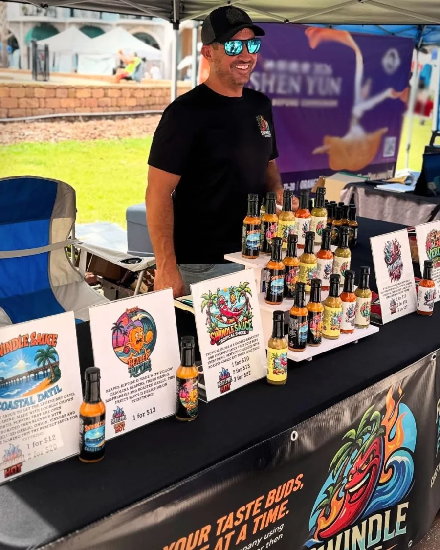 Swindle Sauce booth at Palm Coast Farmers Market with the full sauce lineup on display
